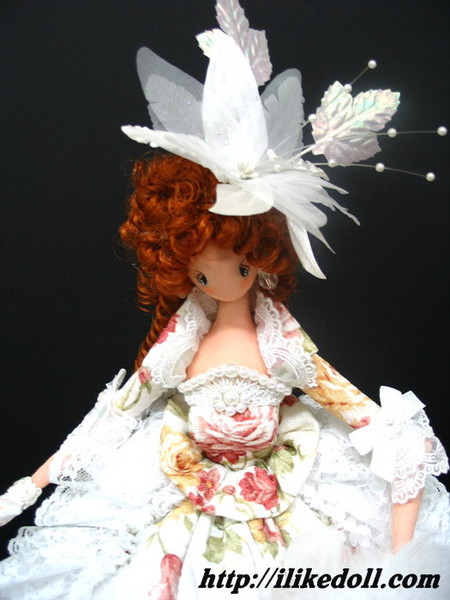 Кукла в белой шляпе с перьями